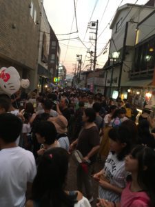 Image shows a narrow street crowded with festival attendees.