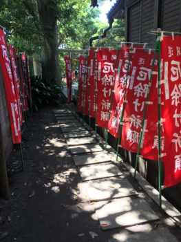 A walkway surrounded by red flags leads to way to the shrine.