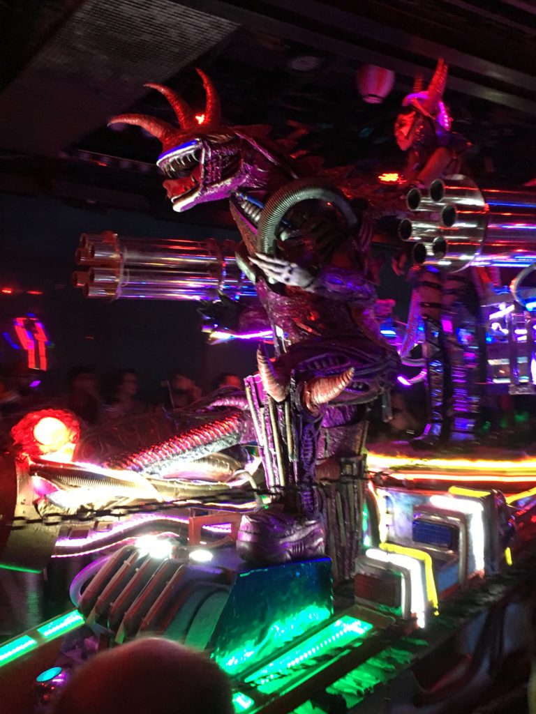 A silver, shiny robot with a rider on top