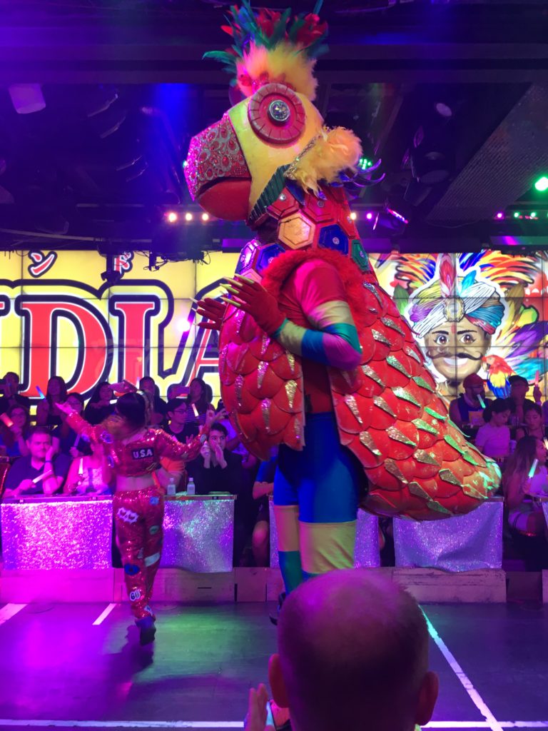 A performer wears a colorful bird costume