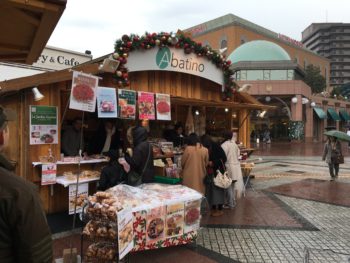 A wooden hut with people window shopping