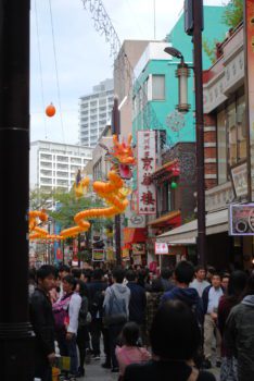Yellow lanterns shaped like a dragon hang above the busy streets of Yokohama's Chinatown