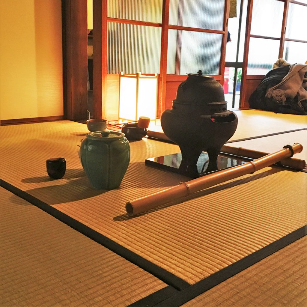 Implements for a traditional tea ceremony are laid out on a tatami mat
