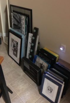 Picture frames stacked together against a wall.
