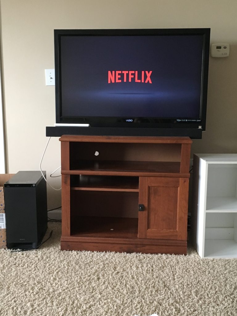 A tv sits on a stand, displaying the Netflix logo.