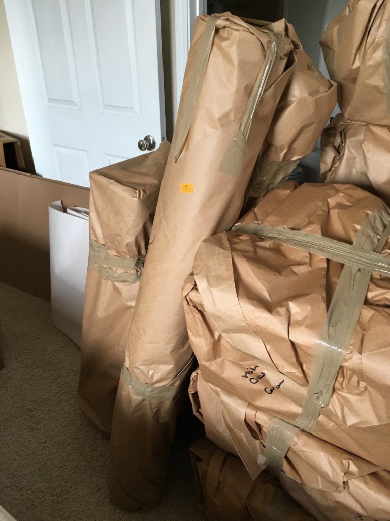 Items wrapped in brown paper wait to be loaded on the moving truck