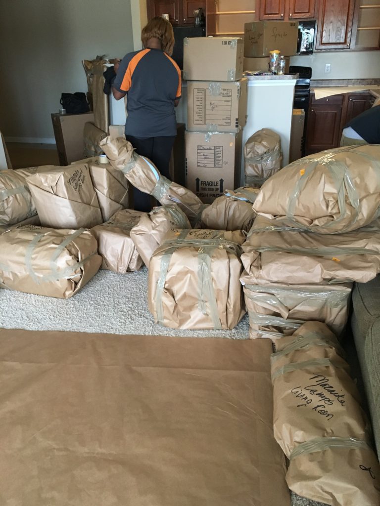 Items wrapped in brown paper, stacked and waiting to be moved to the truck